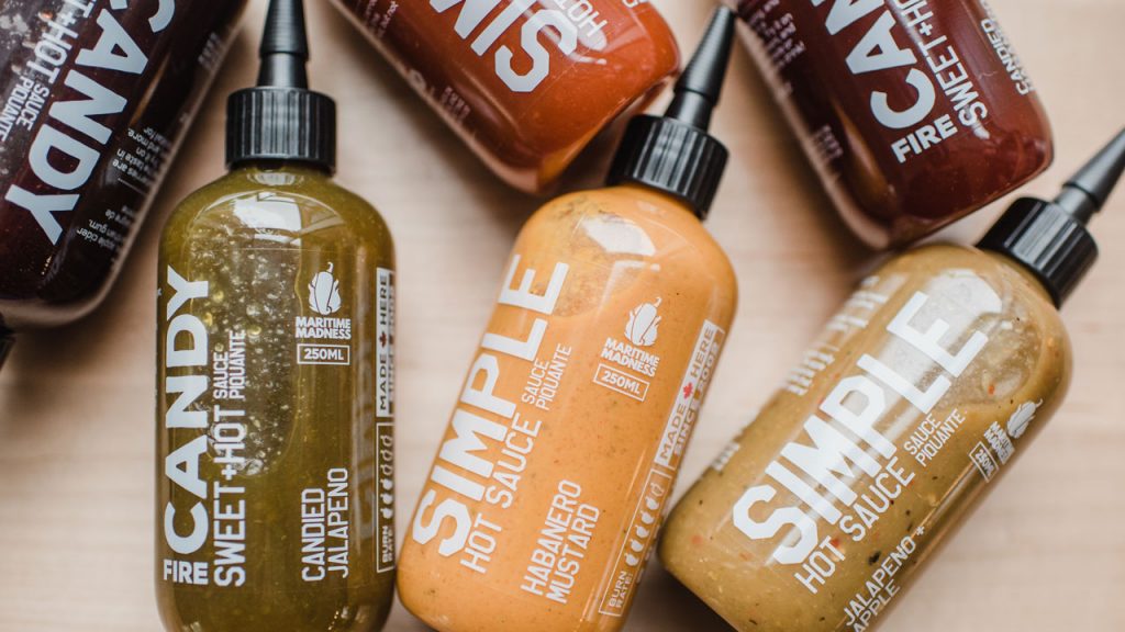 Assorted Maritime Madness hot sauces out on a wooden surface.