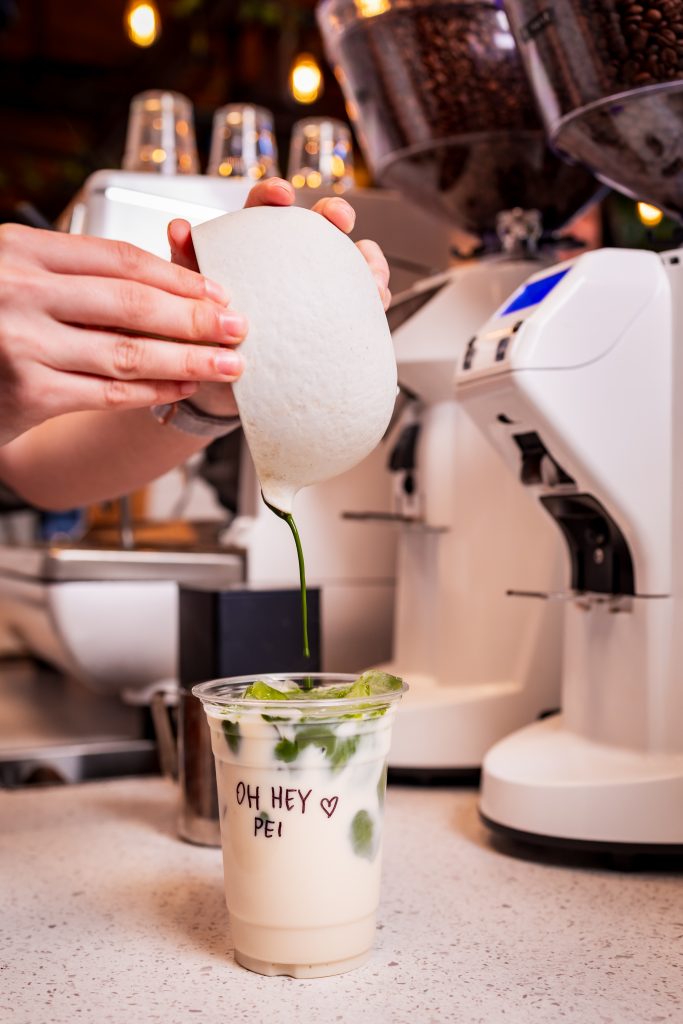 Iced Matcha Latte at Founders’ Food Hall & Market Café | Charlottetown, PEI Barista pouring fresh matcha into an iced latte at Founders’ Food Hall & Market café in Charlottetown, PEI.