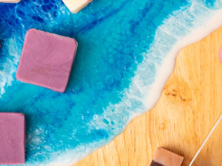 Handmade Fudge Squares from Oh Fudge PEI Assorted handmade fudge squares displayed on a wooden and resin ocean serving board with vibrant blue waves.