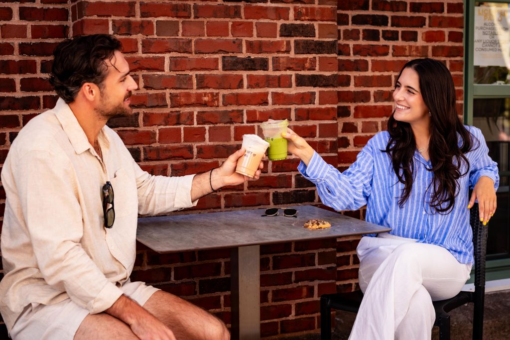 Couple enjoying drinks on the patio at Founders’ Food Hall & Market in Charlottetown, PEI.