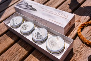 Box set of Oh Hey PEI Island Collection candles displayed on a wooden table, inspired by Prince Edward Island