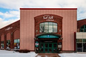 Exterior of Founders Food Hall & Market in Charlottetown with the main entrance and signage on Prince Street in winter.