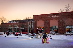 Families skating at Founders Food Hall & Market outdoor rink during winter in Charlottetown PEI