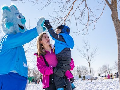 Jack Frost mascot shares a high five with a child and parent during Jack Frost Winterfest in Charlottetown