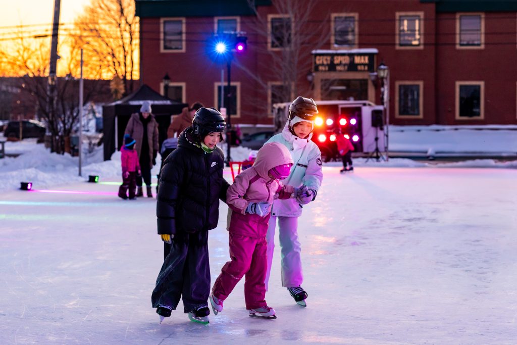 Kids ice skating during Glow Skate with DJ lights at Founders Food Hall during March Break in Charlottetown PEI