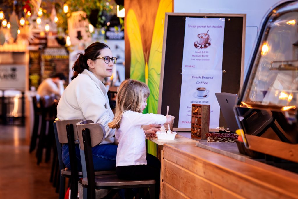Mother and daughter enjoying dessert at a vendor counter inside Founders Food Hall in Charlottetown PEI