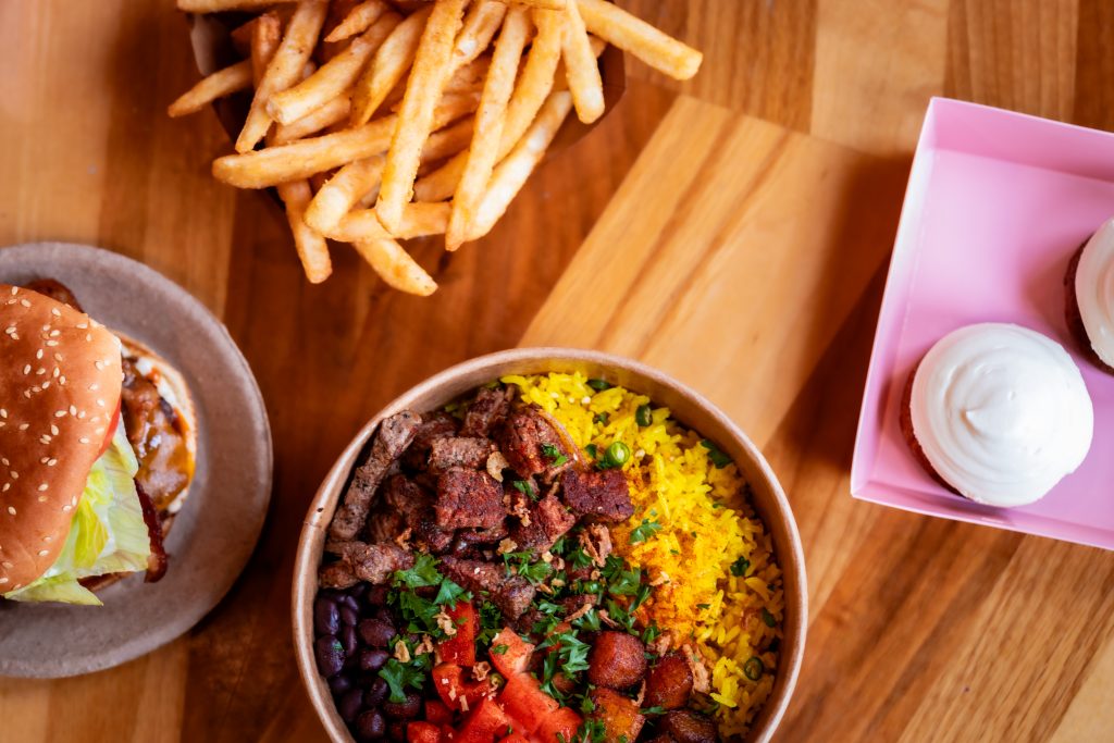 Burger, fries, rice bowl, and dessert from local vendors at Founders Food Hall in Charlottetown